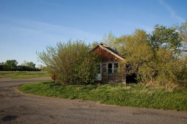 Abandoned building by a gravel road